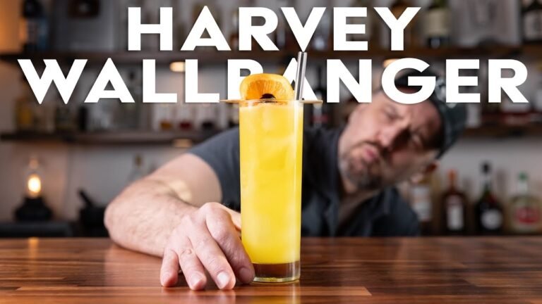 Man presenting Harvey Wallbanger cocktail on bar counter.